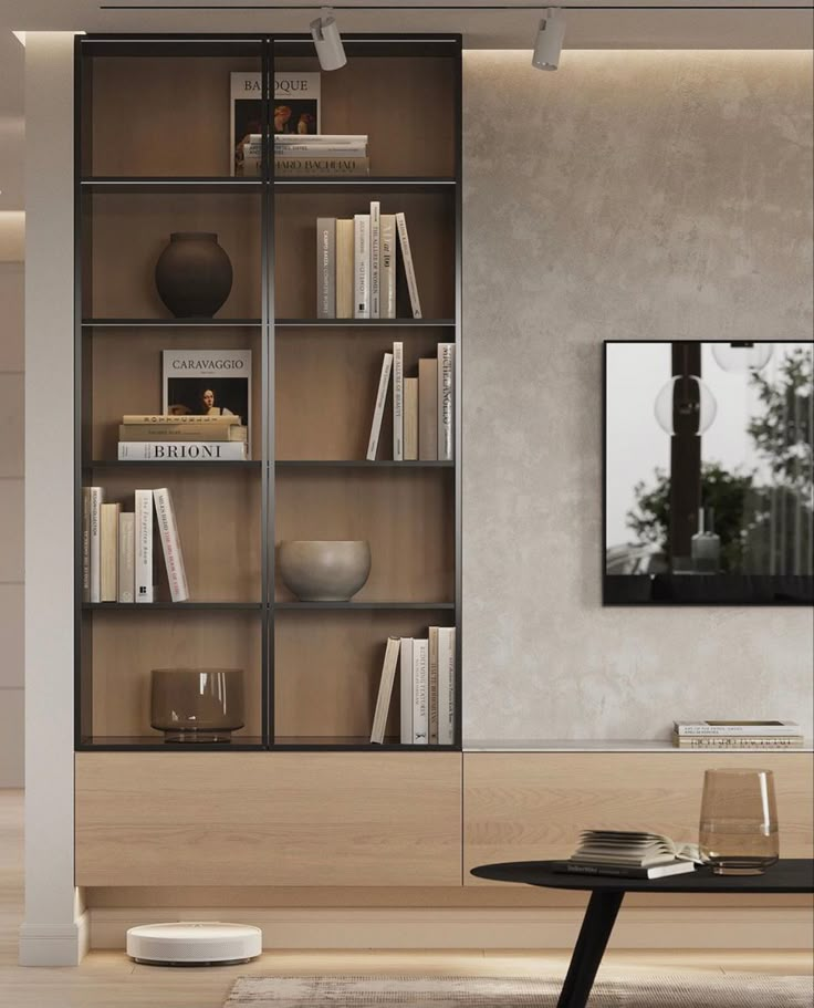 a living room filled with furniture and bookshelves next to a wall mounted tv