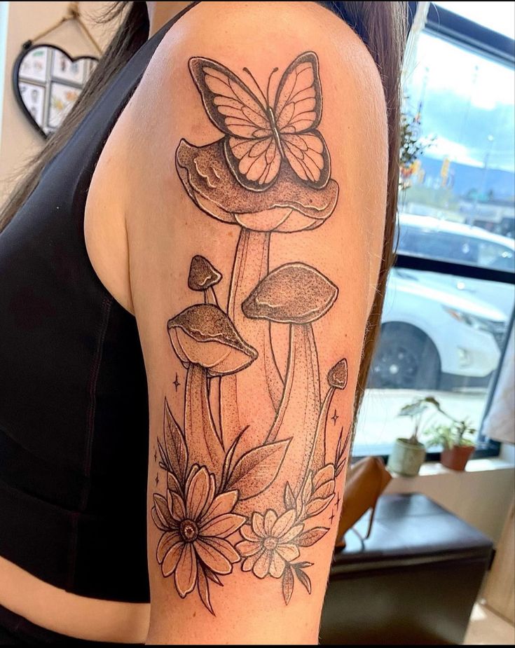 a woman with a butterfly tattoo on her arm and flowers in front of her shoulder