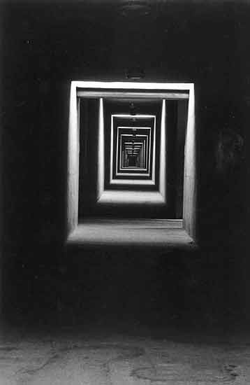 an abstract black and white photo of a square in the middle of a room with light coming through it