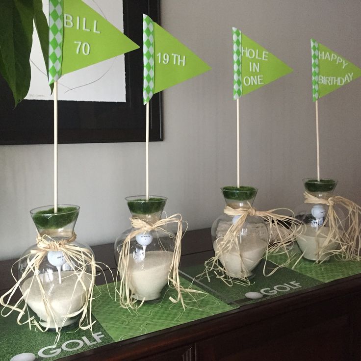 three vases filled with white sand and green flags