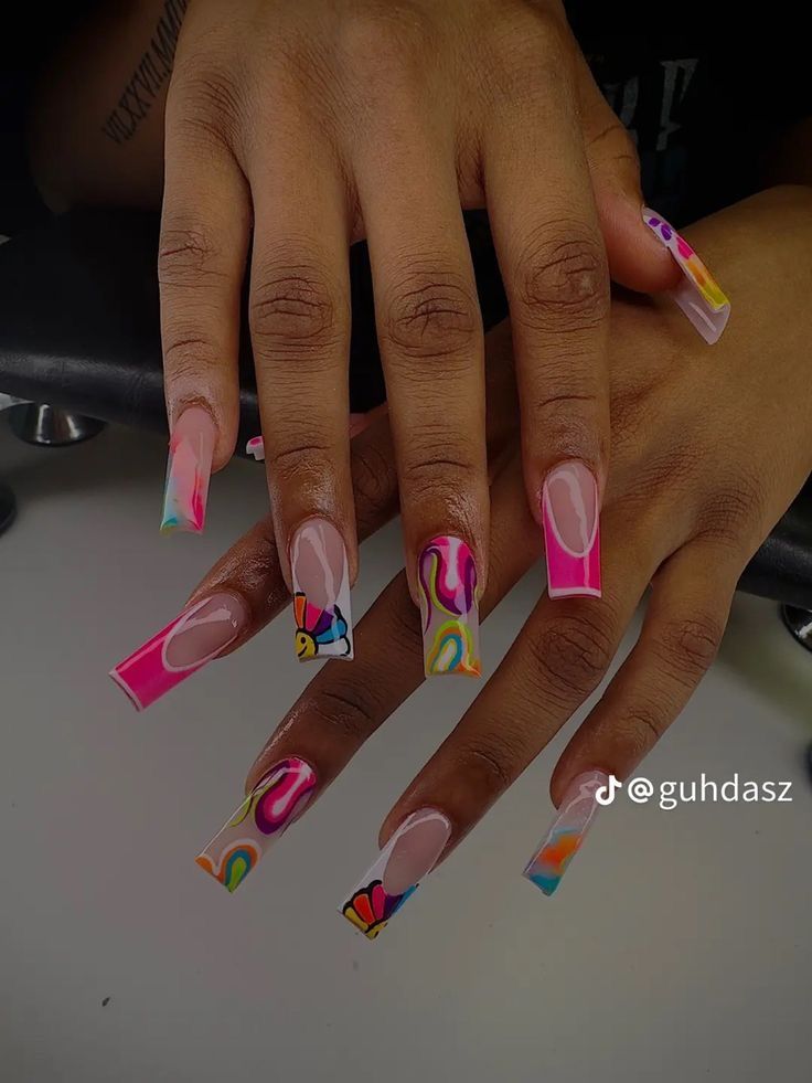 a woman's hand with pink and yellow nail polish