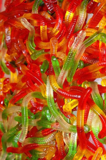 the gummy worms are colorfully colored and have green, yellow, red, and orange colors