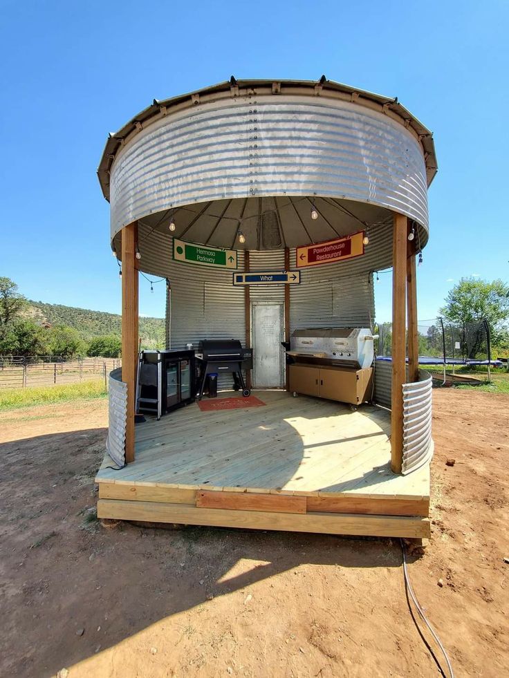 a large metal structure sitting on top of a dirt field