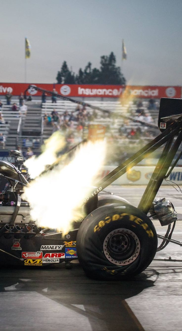 a drag car with its wheels on fire