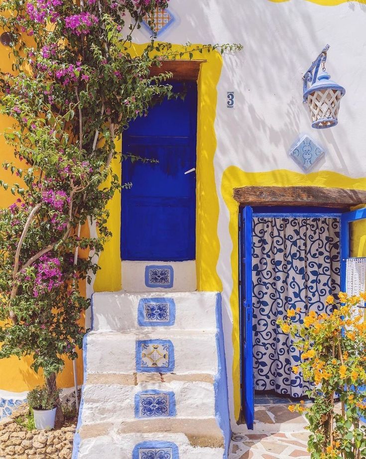 the steps are painted in blue and white with flowers growing on each step, along with potted plants