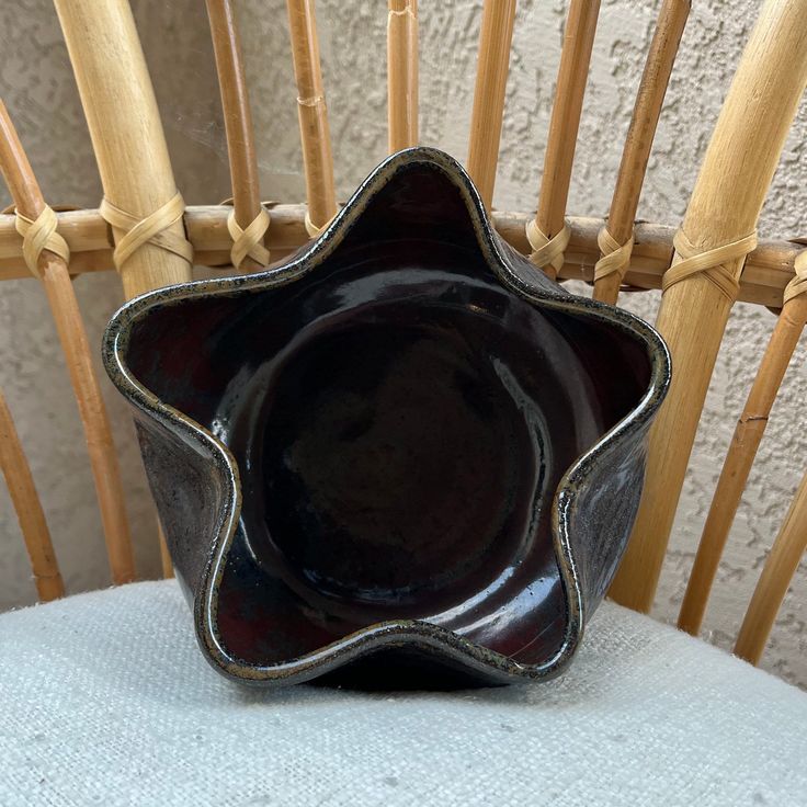 a black bowl sitting on top of a wooden chair