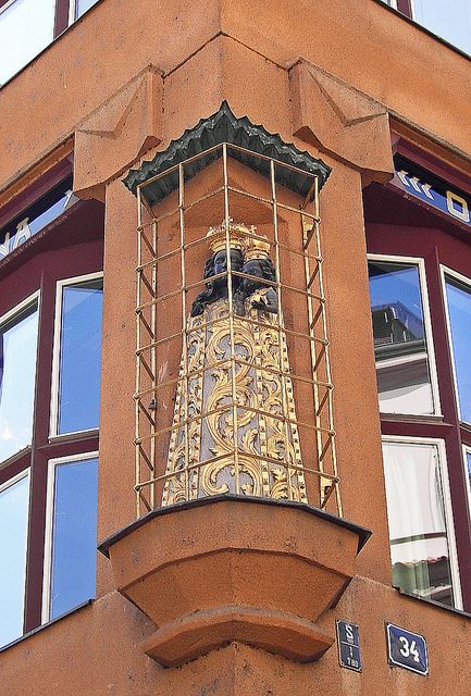 an ornate clock on the side of a building with many windows in front of it