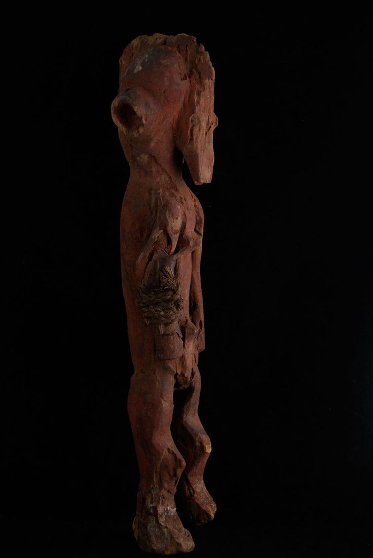 a wooden statue is shown against a black background