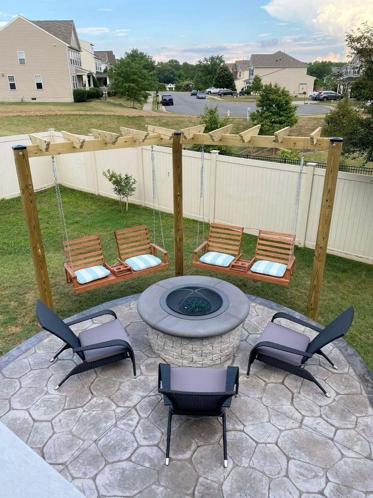 an outdoor fire pit with chairs around it