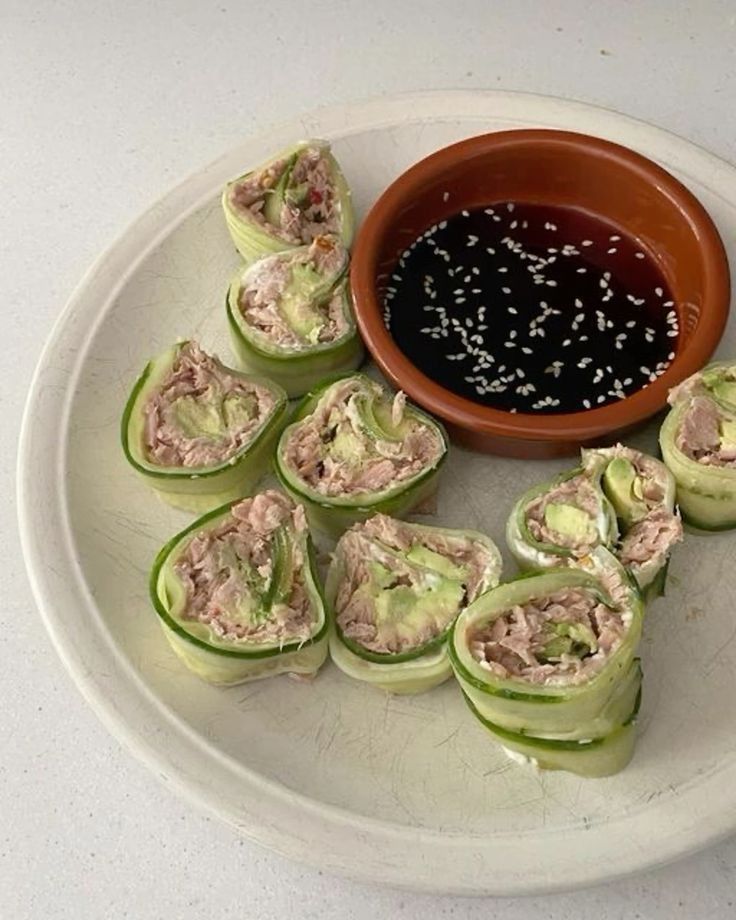 some food is sitting on a plate with a dipping sauce in the bowl next to it