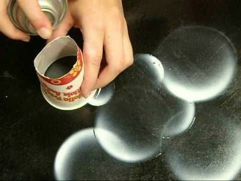 someone is pouring something into a cup on top of a table with circles around it