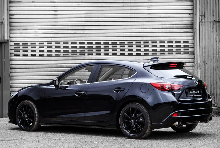 a black car parked in front of a garage door