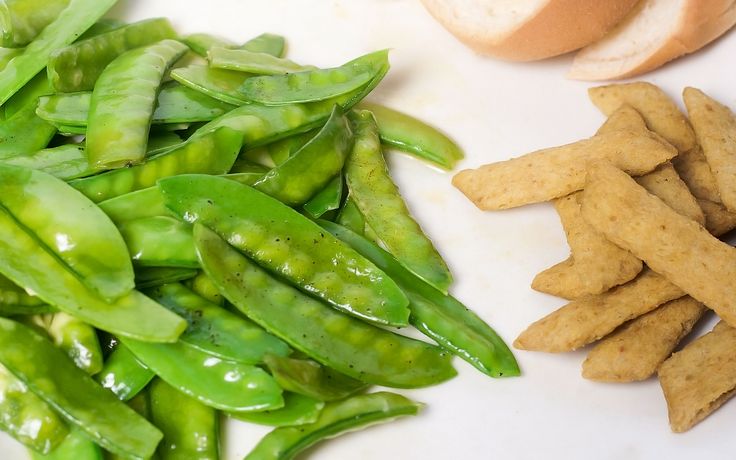 some green beans and other food items on a white surface