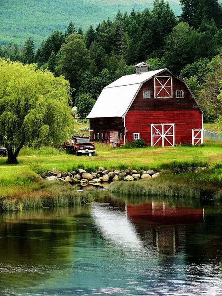 an instagram page with the image of a red barn next to a lake and trees