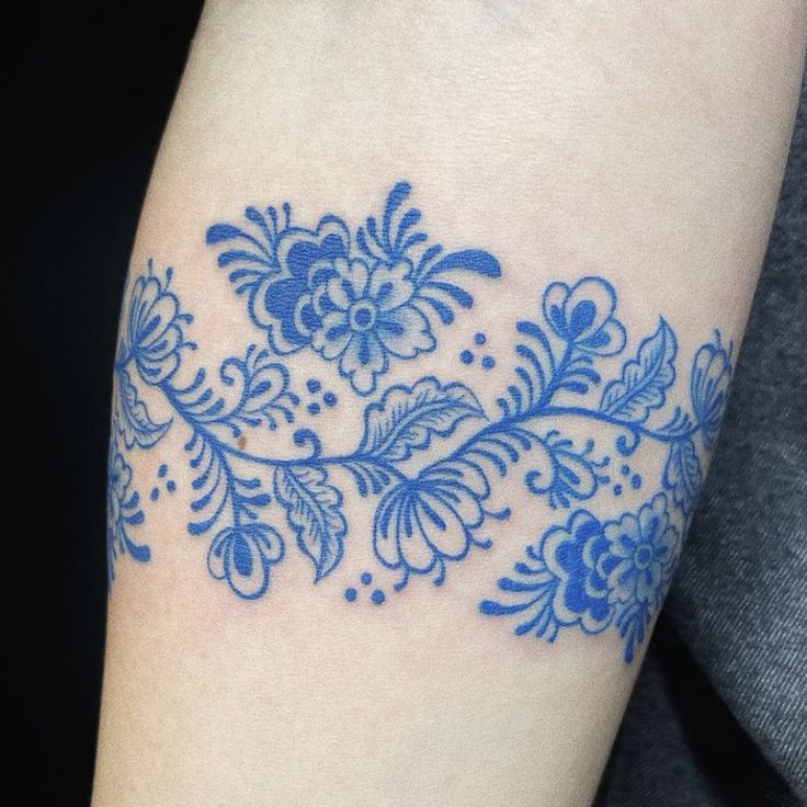 a blue flower tattoo on the arm