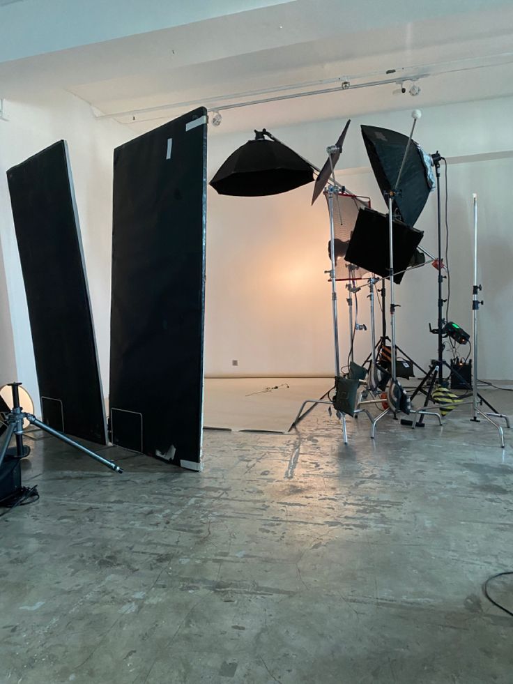 an empty room with several lighting equipment in the middle and one set up on the floor