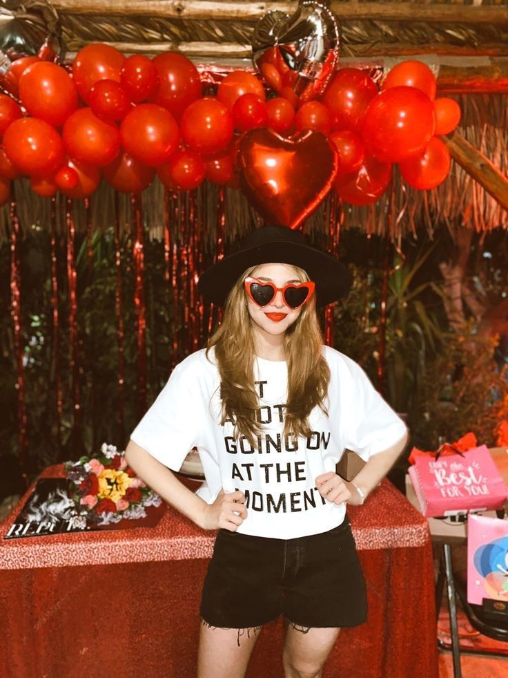 a woman standing in front of a table with balloons