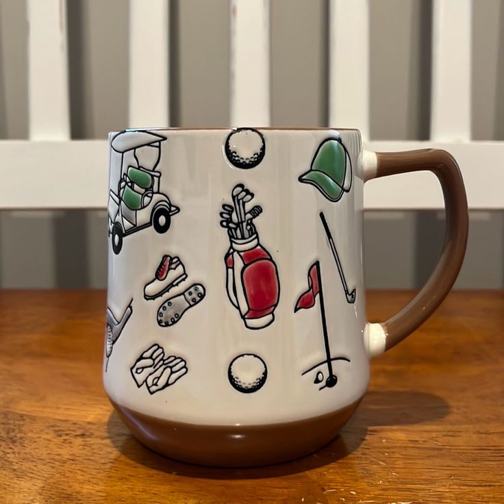 a coffee mug with golf related items on it sitting on top of a wooden table