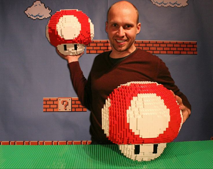 a man holding two lego mario mushroom balls