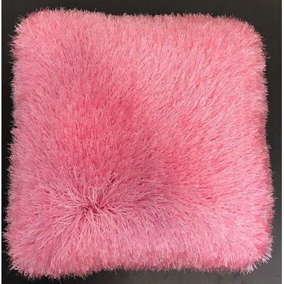 a pink furry pillow sitting on top of a black table