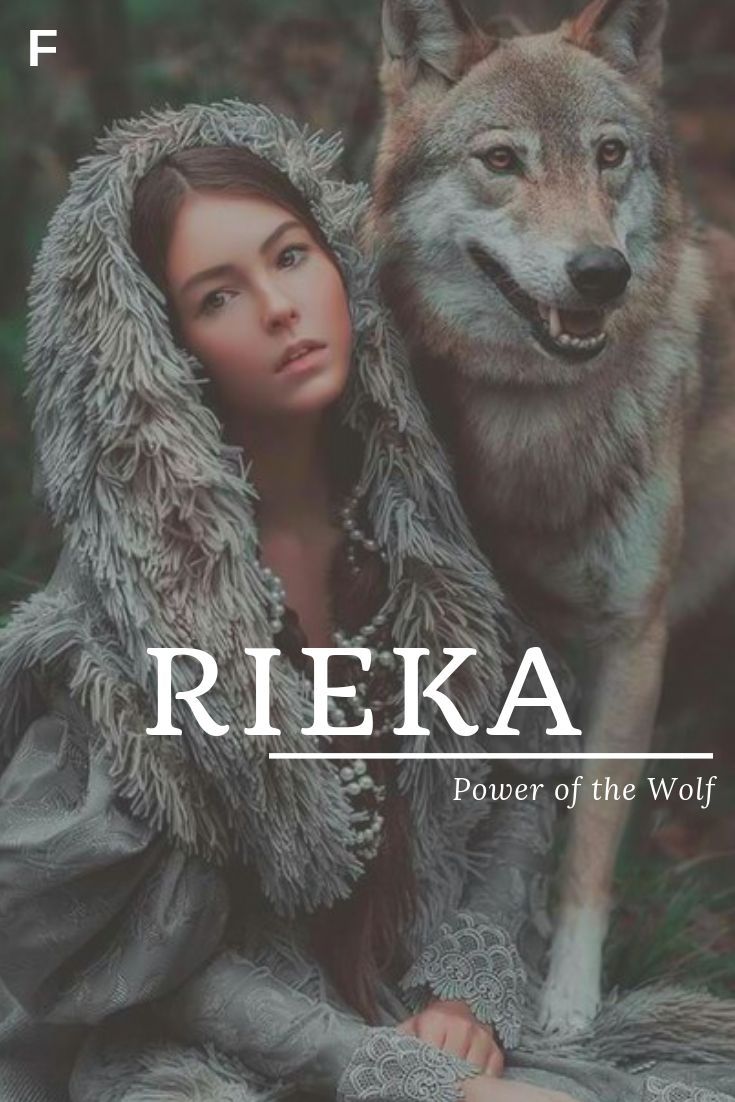 a woman sitting next to a wolf on top of a grass covered field with the words reika