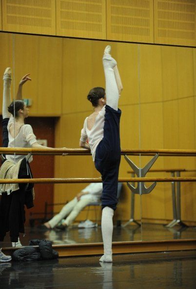 two young ballerinas are practicing their moves in the ballet class at the school