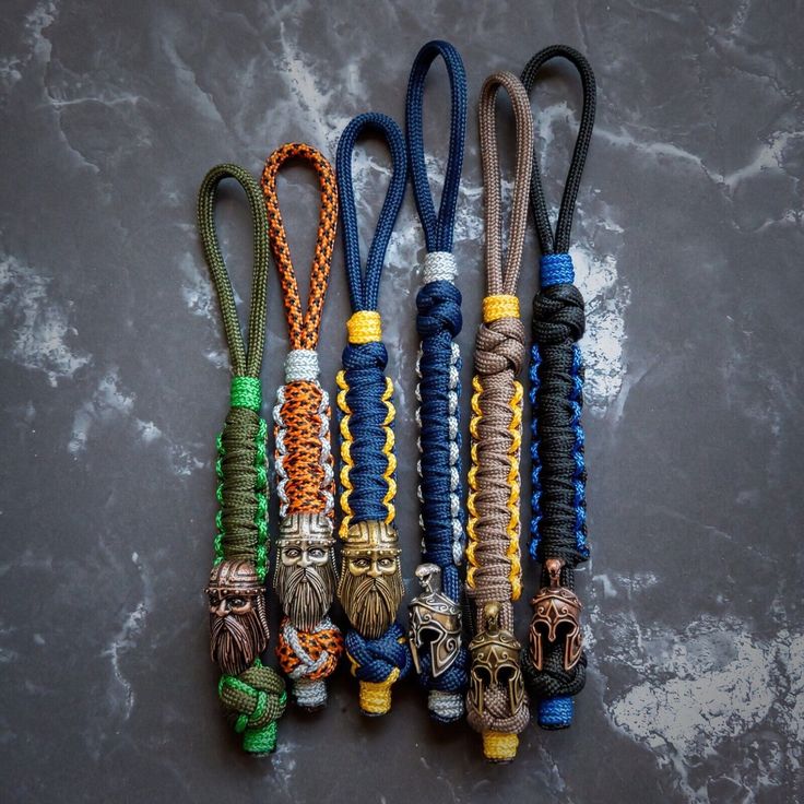 several different colored cords with tassels and beads attached to one another on a gray surface