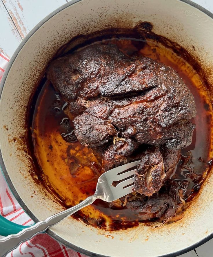 a pot filled with meat and sauce on top of a table