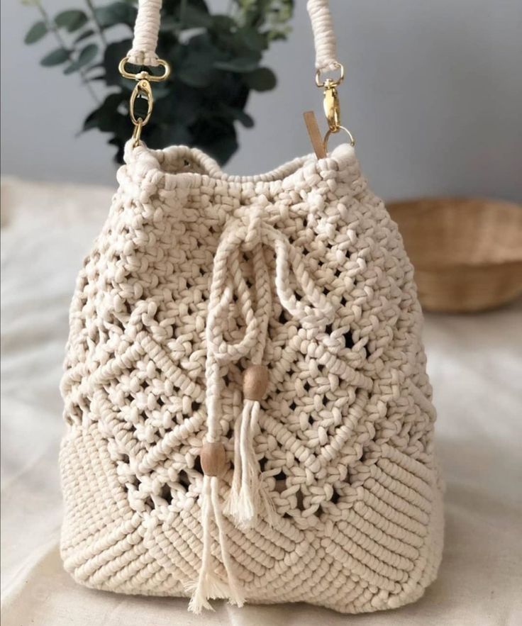 a crocheted white purse sitting on top of a bed