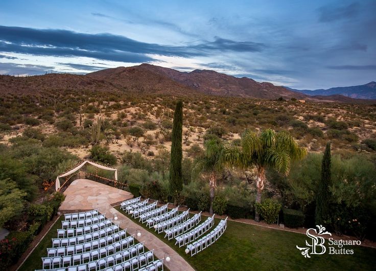 an aerial view of a wedding set up in the desert with mountains in the background