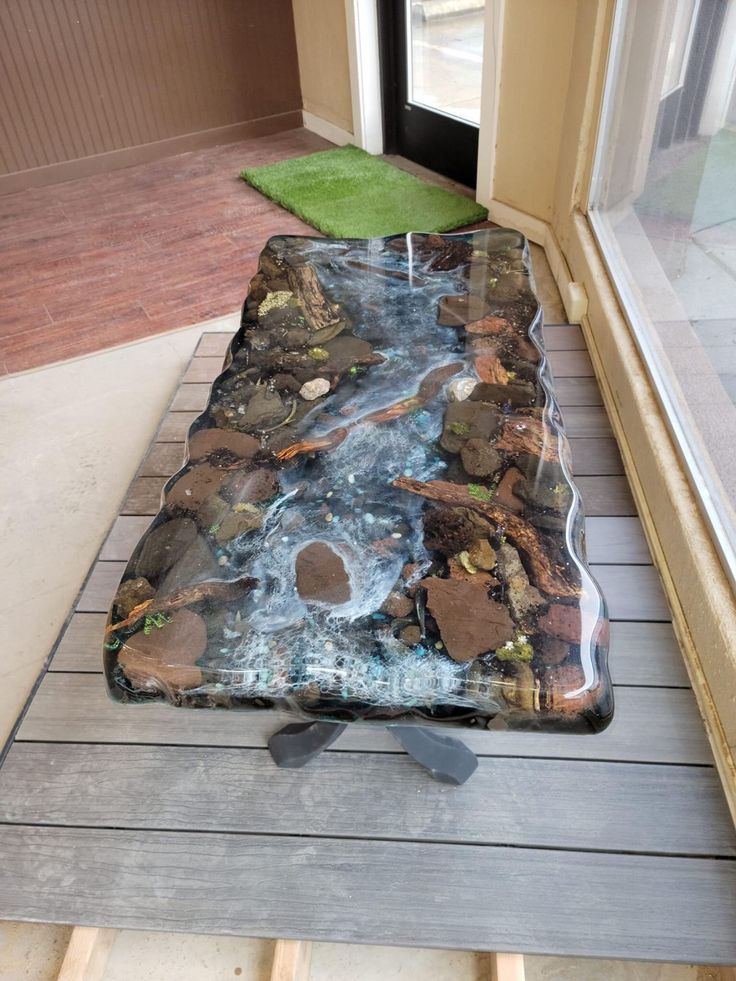 a glass table sitting on top of a wooden floor in front of a sliding glass door