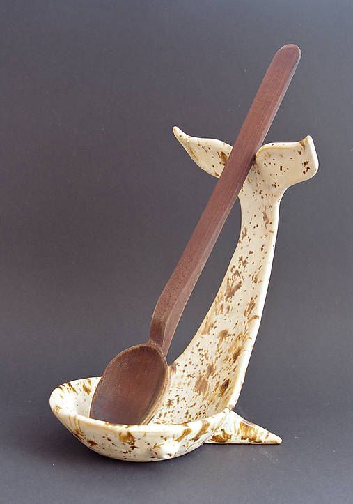 a wooden spoon sitting on top of a banana peel shaped like a whale with a long tail