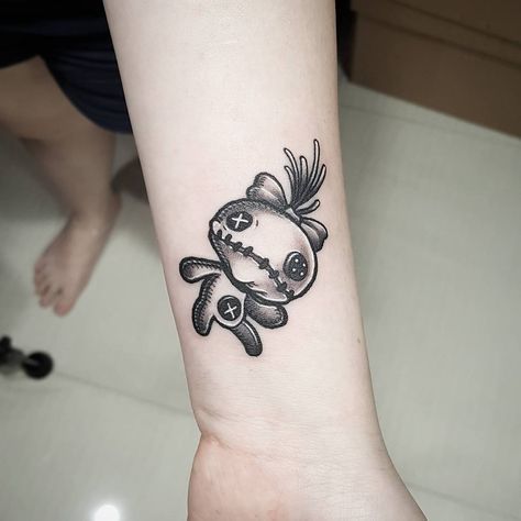 a black and white tattoo on the wrist of a woman with a fish in it