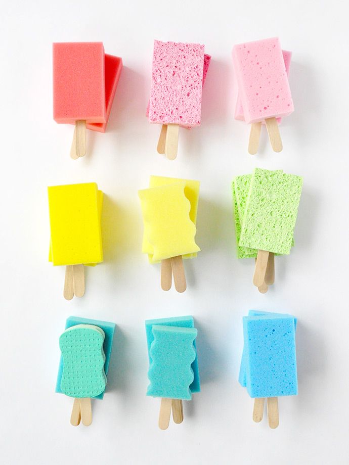 four popsicles with different colors and shapes on top of each other, sitting next to each other