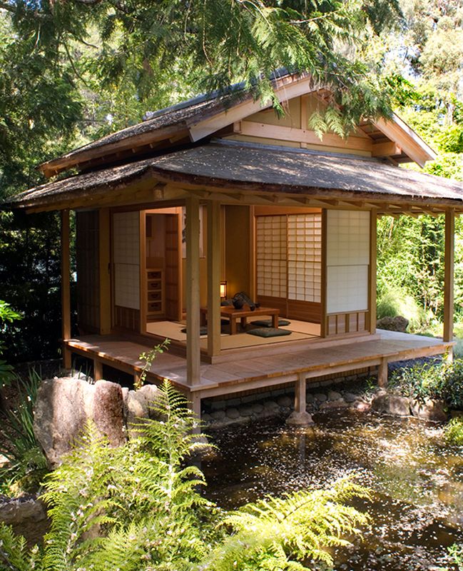 a small wooden building sitting in the middle of a forest