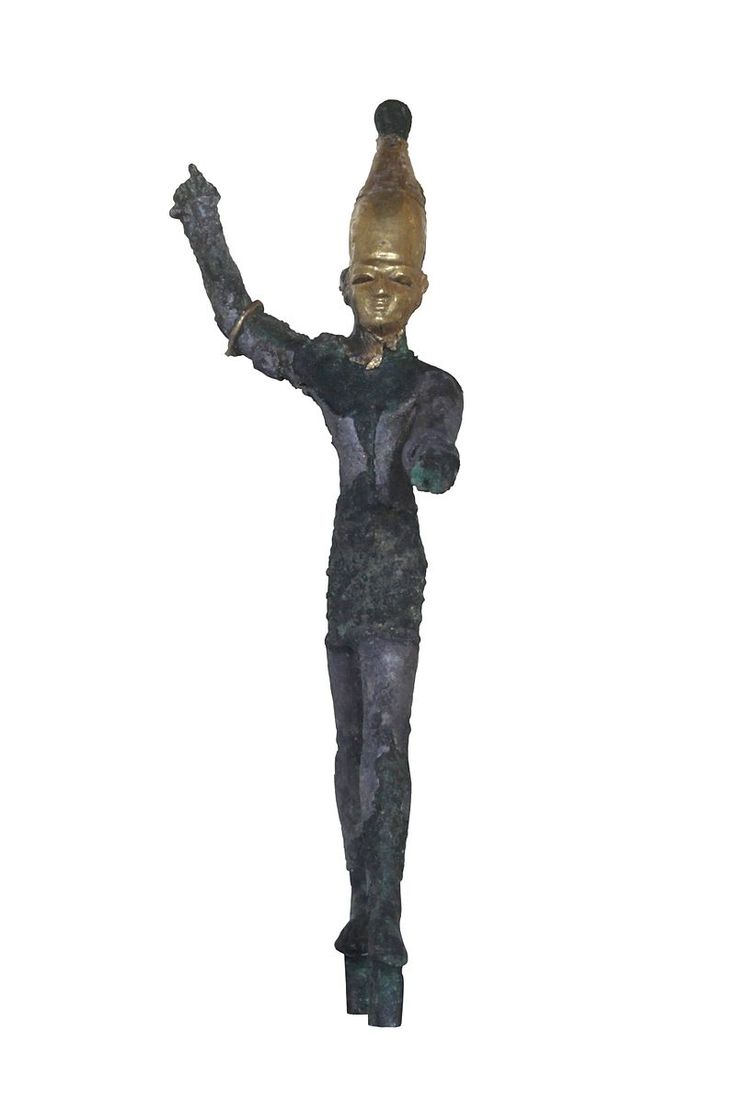 a statue with a bottle on it's head holding something in one hand and an object in the other