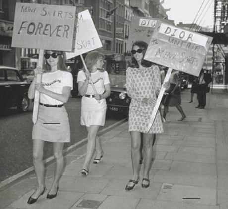 three women walking down the street holding signs