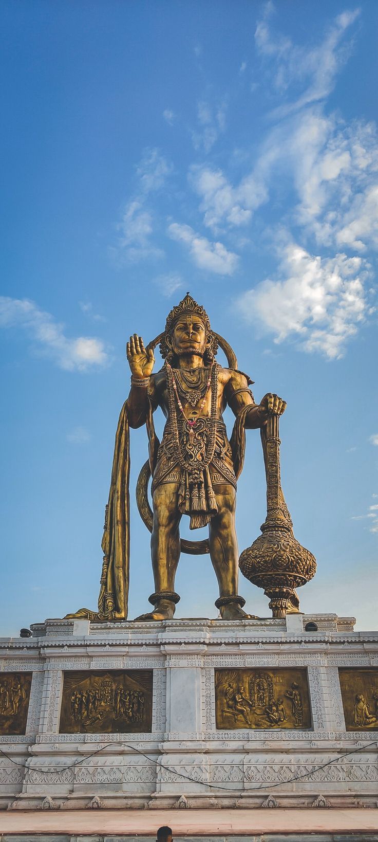 the statue is in front of a blue sky