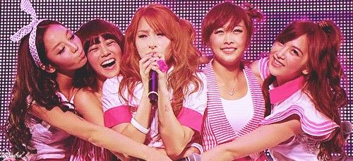 girls'generation performing on stage with microphones in their hands and wearing pink outfits