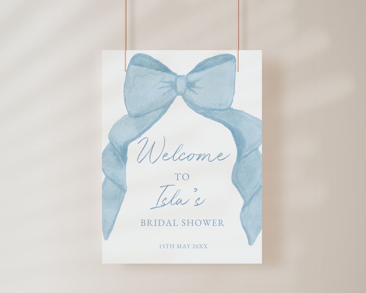 a welcome sign with a blue bow hanging from it's side on a wall