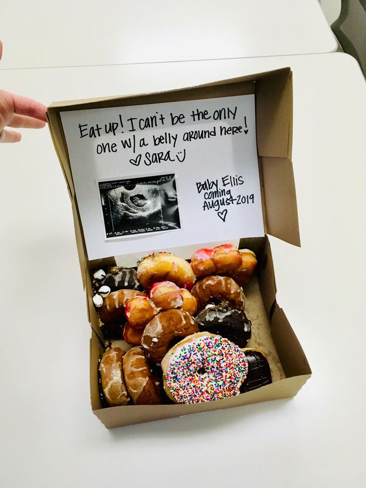 a box filled with lots of donuts sitting on top of a white countertop