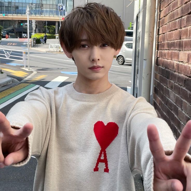 a young man is holding out his hands in front of the camera and making two fingers up