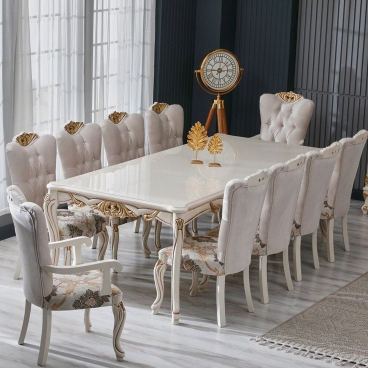 a dining room table with chairs and a clock on the wall in front of it