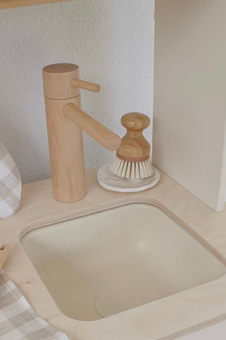 a bathroom sink with a wooden brush and soap dispenser