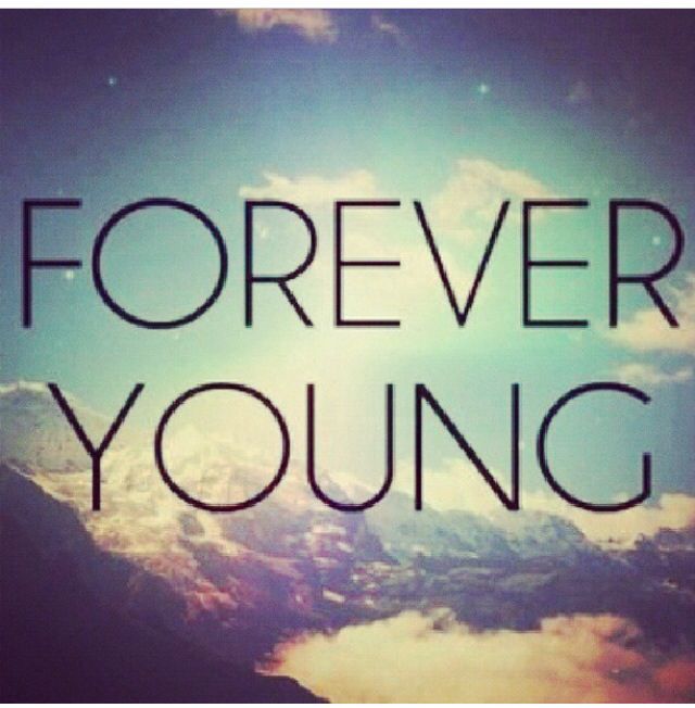 the words forever young are in front of a sky with clouds and sun shining through it