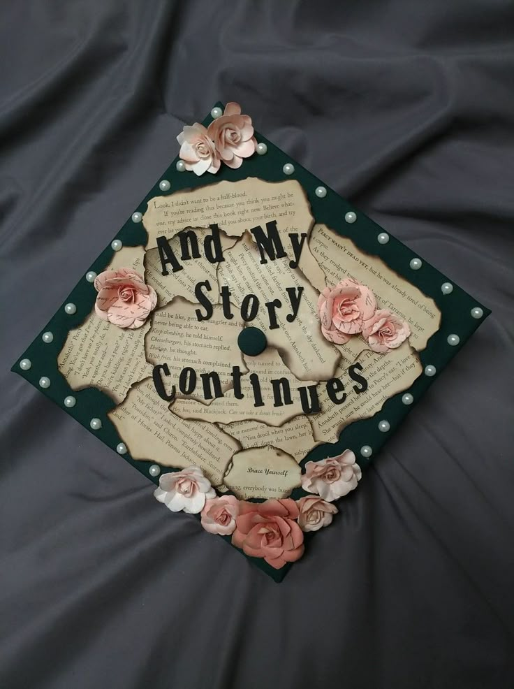 a graduation cap that says and my story continues with flowers on the front, and an old book page in the middle