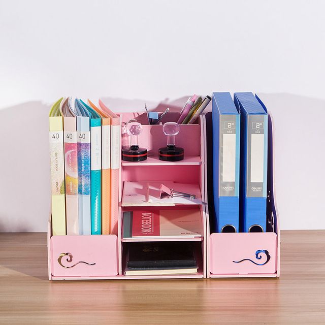 a pink book shelf filled with books on top of a wooden table