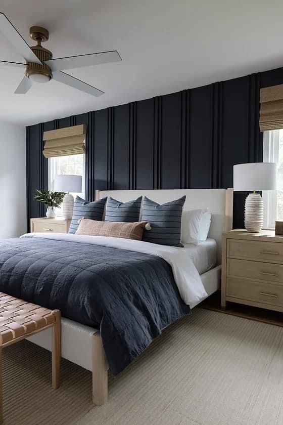 a bedroom with blue walls and white bedding, two nightstands and a bench in front of the bed