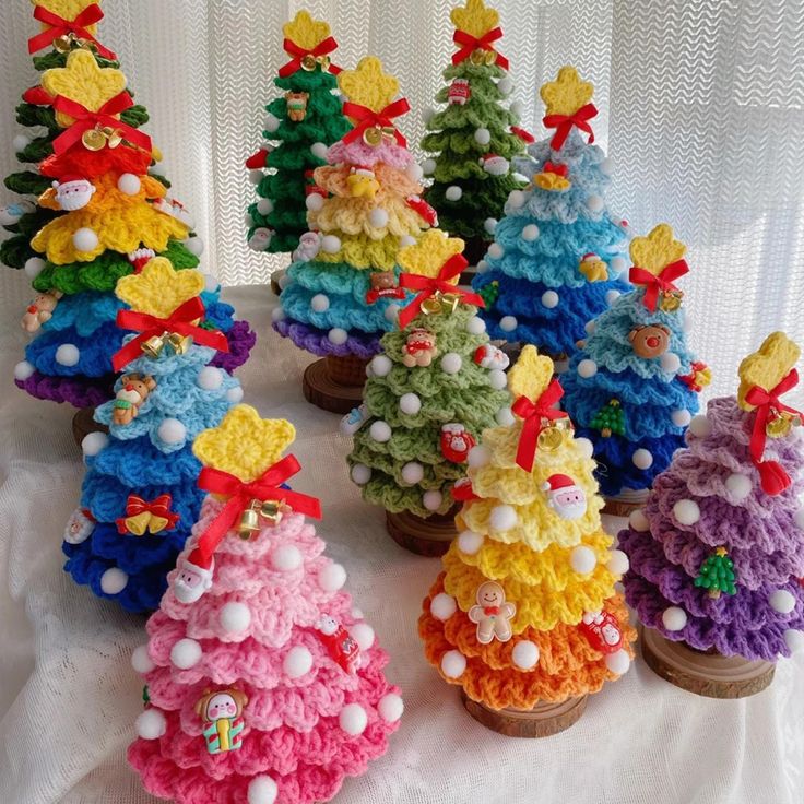 small crocheted christmas trees with bows on them