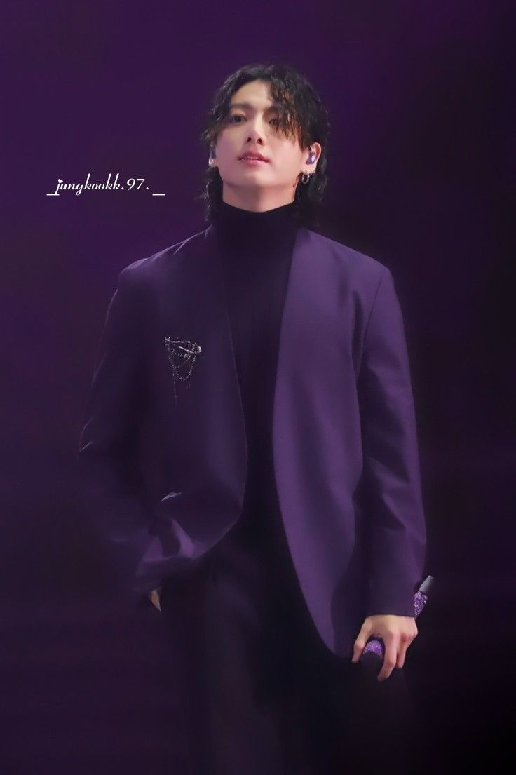 a male in a purple suit and black shirt